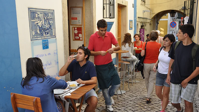 Young people at an outdoor cafe table in a Sintra lane