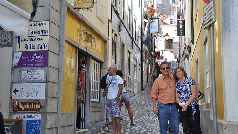 Narrow Sintra street with shop signs and visitors