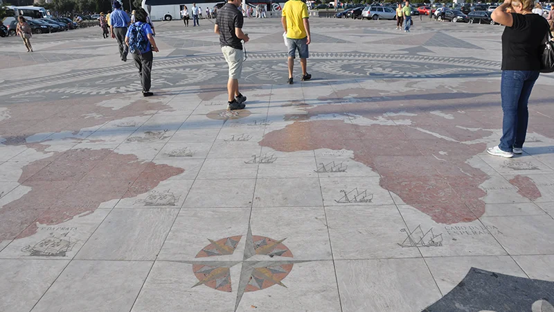 The compass rose pavement at Belem with people walking across it