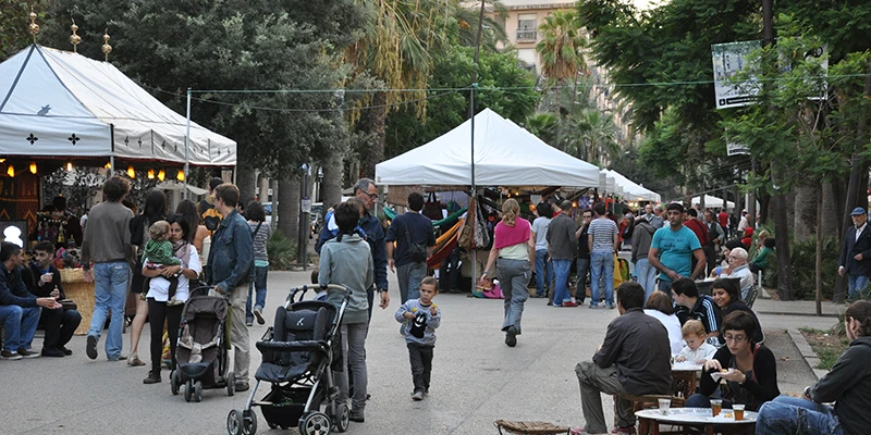 Pedestrians walking through the Raval neighborhood with its characteristic narrow streets and local shops