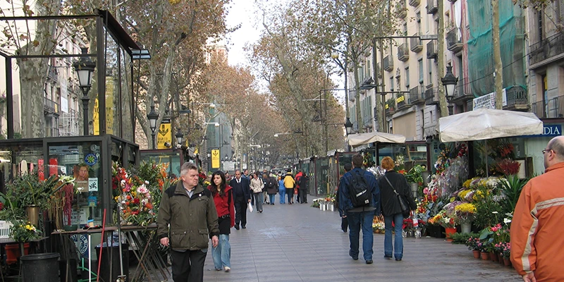 Visitors exploring a winding pedestrian lane in Barcelona's historic center