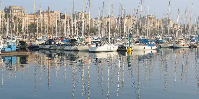 Barcelona waterfront with palm trees and Port Vell marina