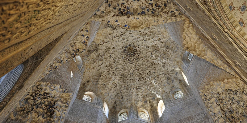 Geometric tilework and calligraphic inscriptions covering the walls of the Nasrid Palaces