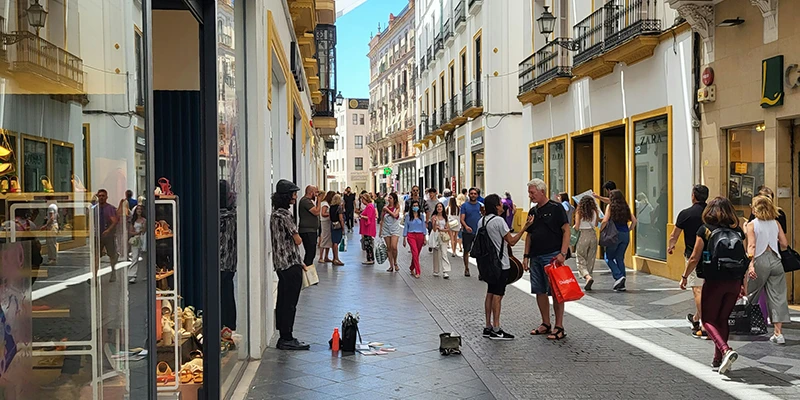 Families gathering in a lively Seville plaza surrounded by colorful buildings