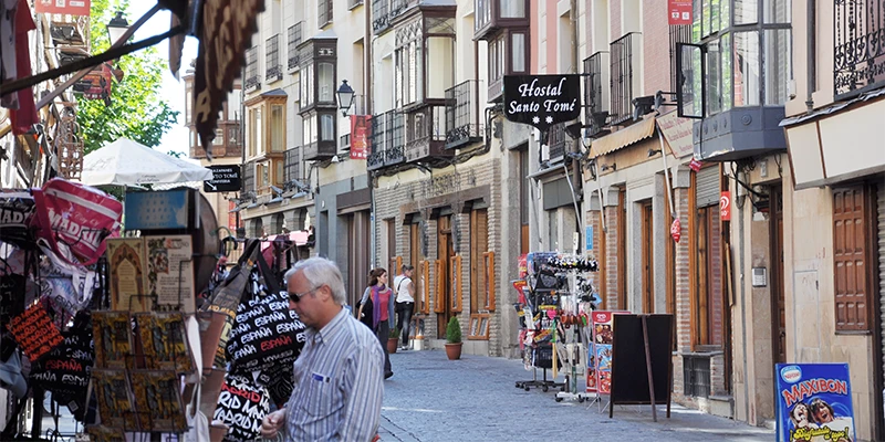 Narrow lane widening to join a busier street in Toledo