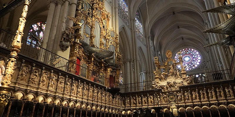 Ornate choir stalls and gilded main altar retablo inside Toledo Cathedral