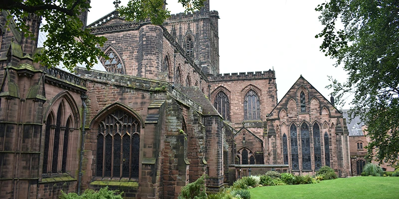 Chester Cathedral in red sandstone seen across the green