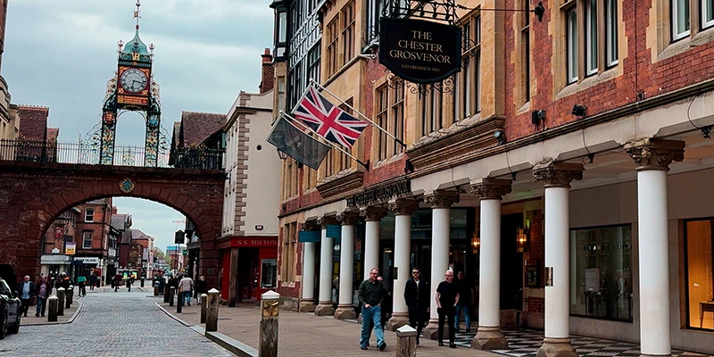 The Eastgate arch in Chester seen at street level with shops on both sides