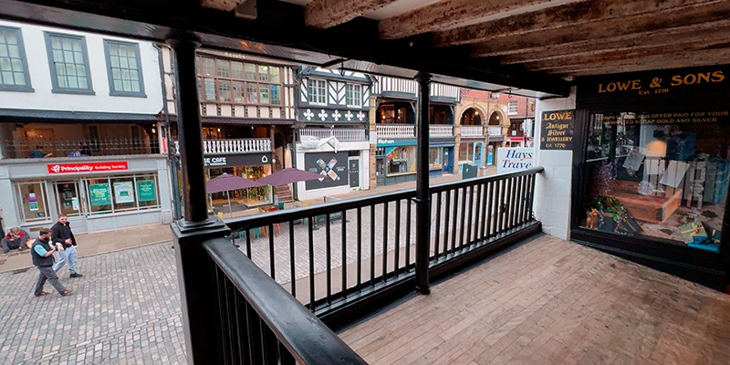 The wooden railing and low beams of the upper Rows walkway in Chester