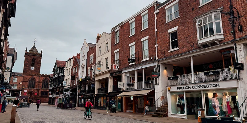 Chester street with a sandstone church tower at the far end