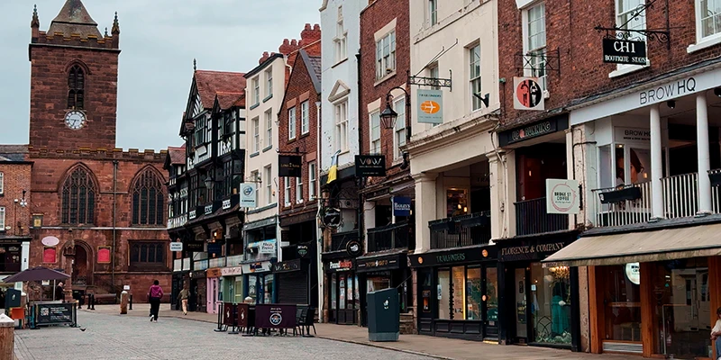 Red sandstone church tower rising above timbered buildings in Chester