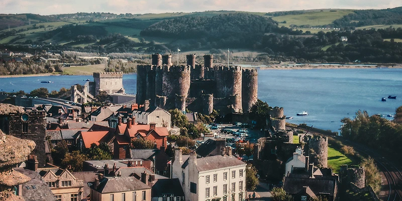Conwy Castle and the walled town seen from above, with the estuary and hills beyond