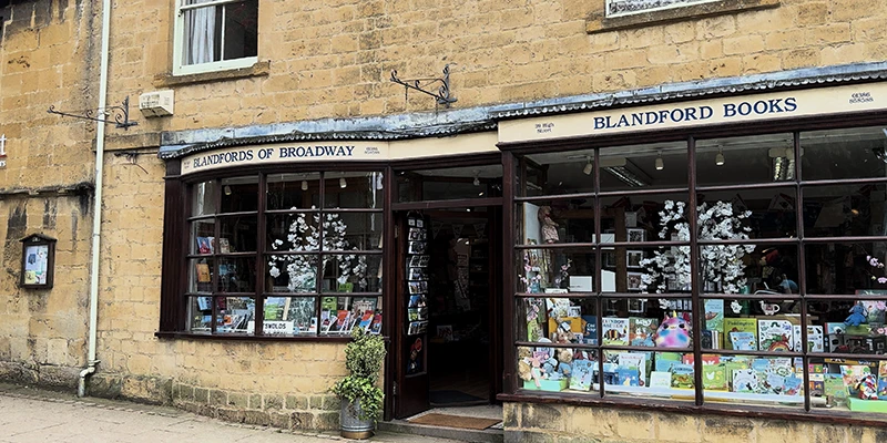 Blandford Books shop frontage with two large bay windows full of titles, and Blandfords of Broadway sign above