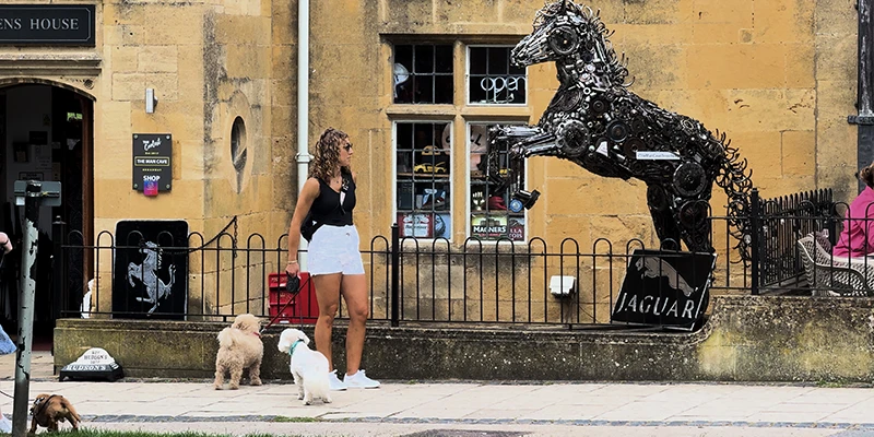 A metal sculpture of a rearing horse made from automotive parts, mounted outside The Man Cave shop