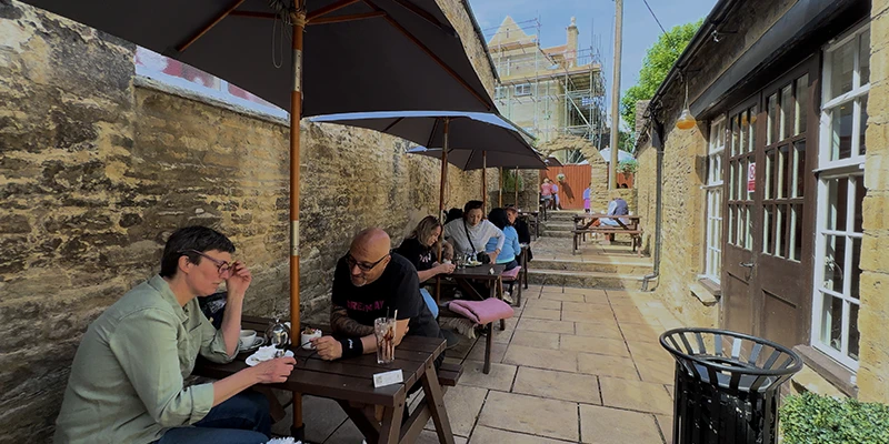 Outdoor cafe seating with diners under sun umbrellas