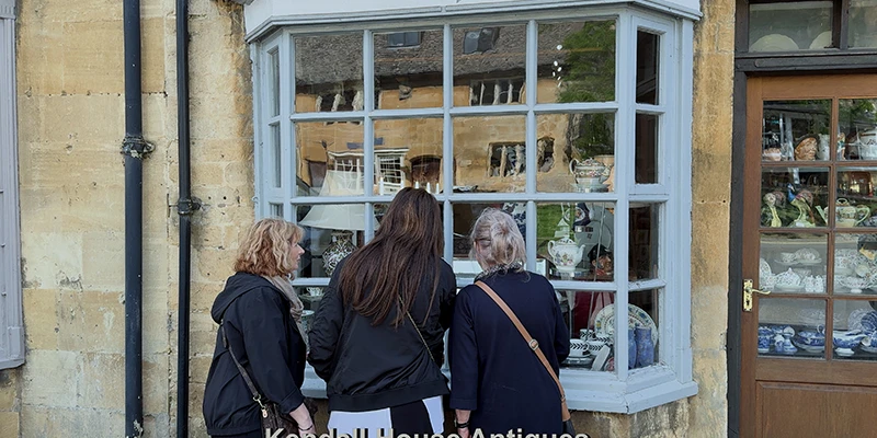 Three women looking in the window of Kendall House Antiques
