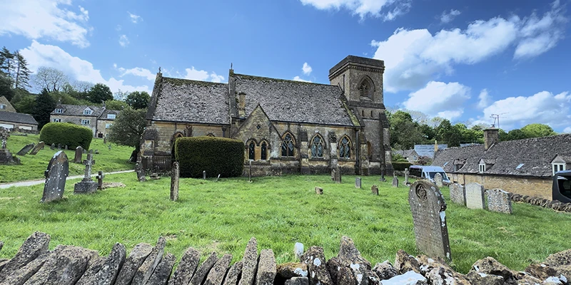 St Barnabas Church seen from the churchyard with stone wall in foreground