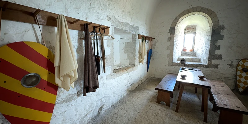 Re-created chamber at Dover Castle with a painted shield and table