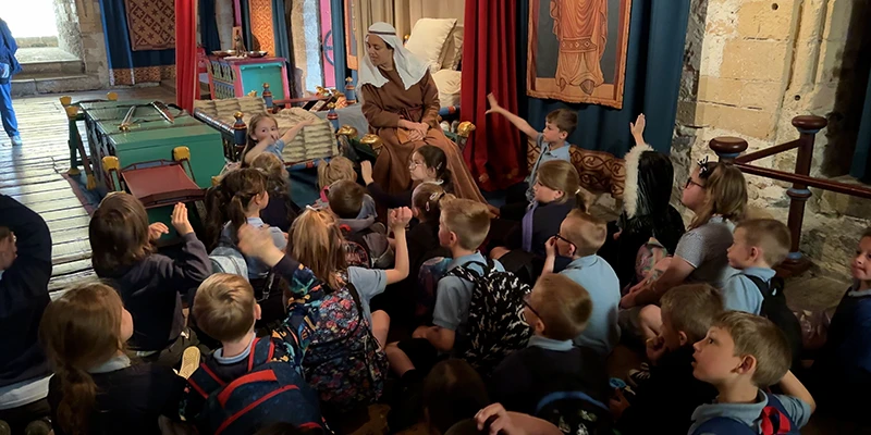 Students with a costumed guide in a room at Dover Castle
