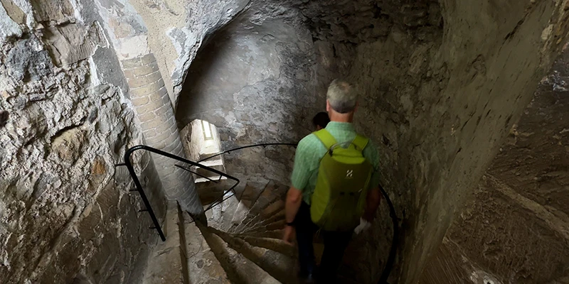 A visitor on the stairs in a passage within Dover Castle