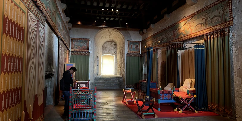 Room at Dover Castle hung with red and orange textiles