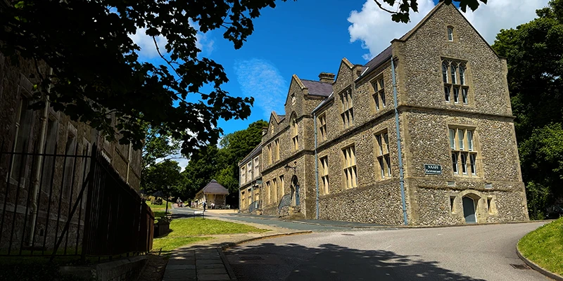 Tree-lined drive past a stone building at Dover Castle
