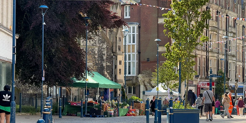Market stalls under green canopies in Dover town center