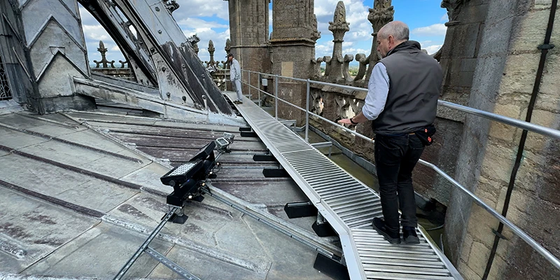 A cathedral guide leading the roof tour along the walkway at Ely