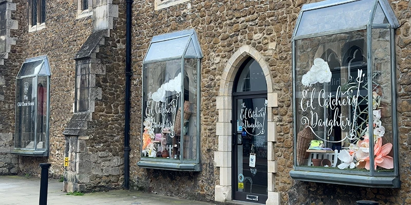 A shop window set into a medieval stone building on High Street in Ely