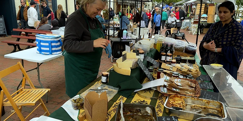 A vendor serving hot food from a stall at Ely market