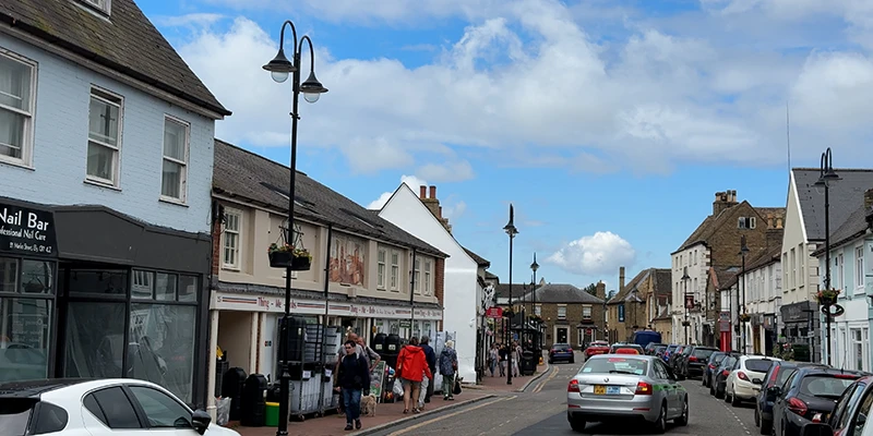 Shops and traffic on a broad street in the center of Ely