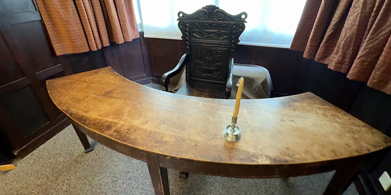 Cromwell's office with a round table and helmet in his house at Ely