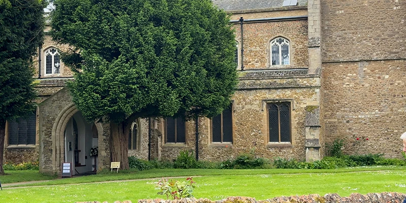 The stone exterior and churchyard of Saint Mary's Church in Ely