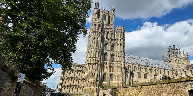 The west tower of Ely Cathedral framed by trees