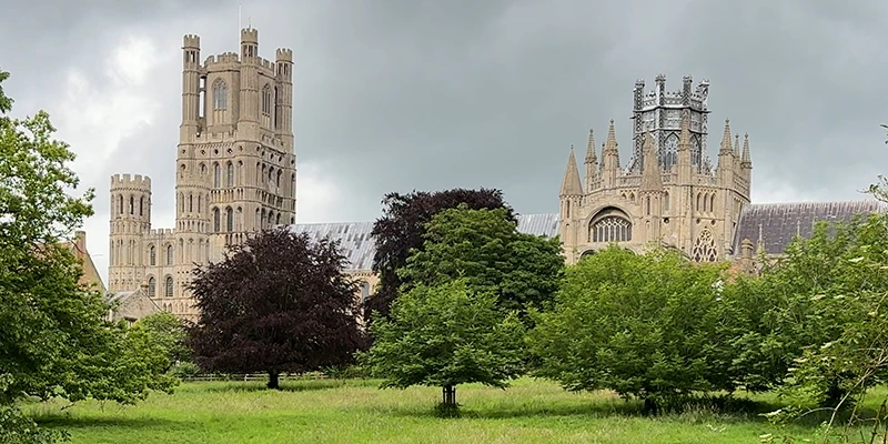 Ely Cathedral rising above trees and parkland