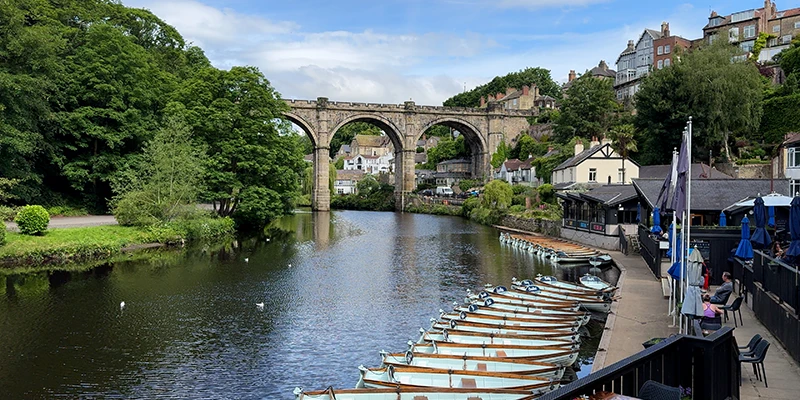 The River Nidd at Knaresborough with moored boats and the viaduct beyond