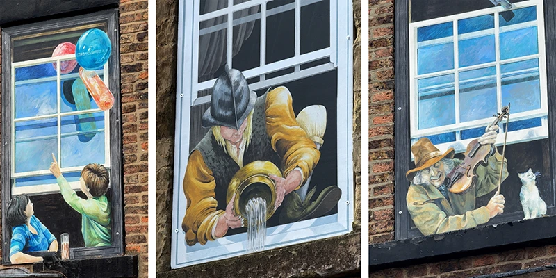 A painted window in Knaresborough showing children reaching for balloons