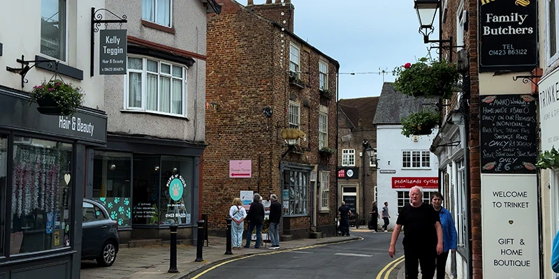 Hanging baskets above the shops on High Street in Knaresborough