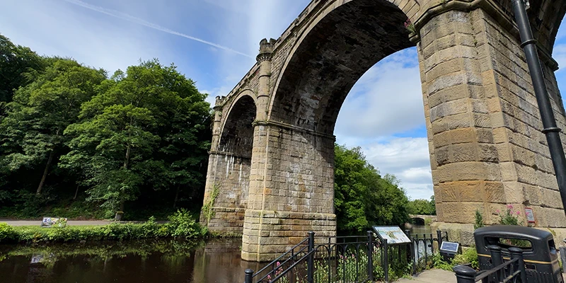 A close view of the sandstone arches of the Knaresborough viaduct from the riverbank
