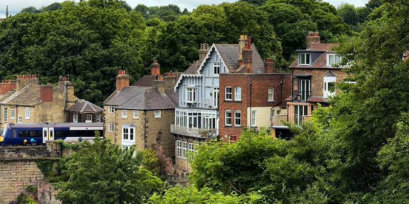 Houses on the hillside at Knaresborough with a train crossing above