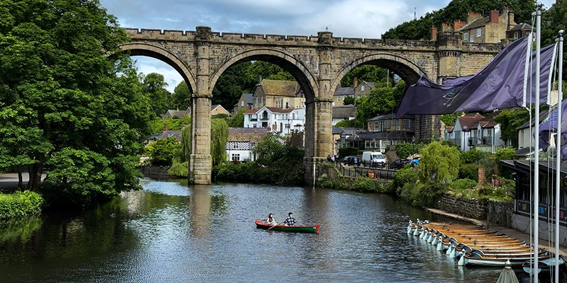 A rowing boat on the River Nidd beneath the Knaresborough viaduct