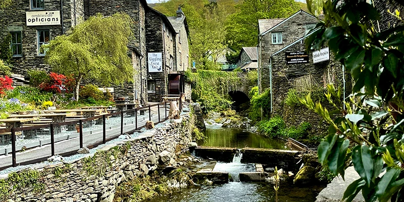 A footbridge and café terrace beside the beck in Ambleside