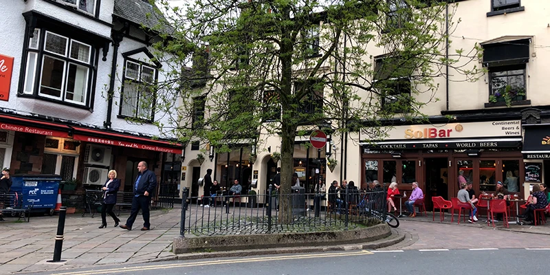 A restaurant-lined street in the evening in Bowness