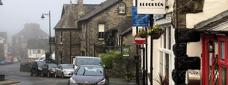 Stone buildings and a red telephone box on a foggy street in Windermere