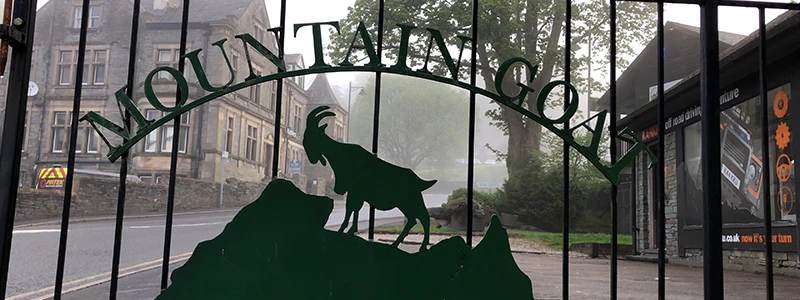 Green gates with the Mountain Goat logo at the tour company yard in Windermere