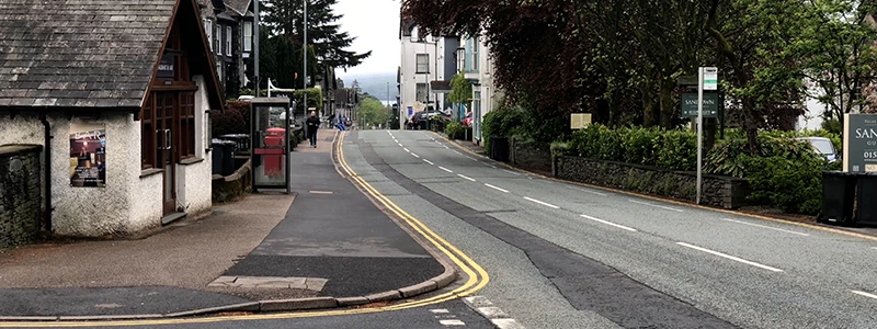 White cottage and red telephone box beside the road leading out of Windermere