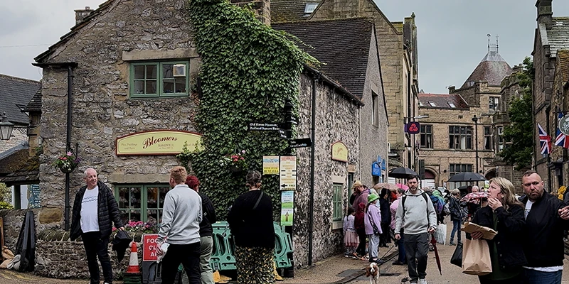 People walking through the streets of Bakewell among stone buildings