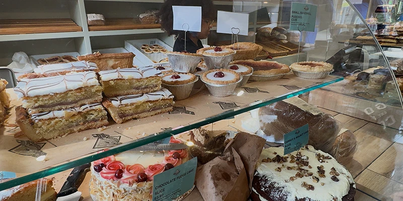 A display case of freshly baked Bakewell puddings and cakes