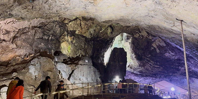 Colored lighting illuminating a great cavern chamber at Castleton
