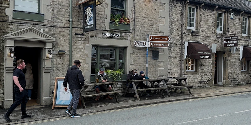 A country pub with picnic tables on a Castleton street